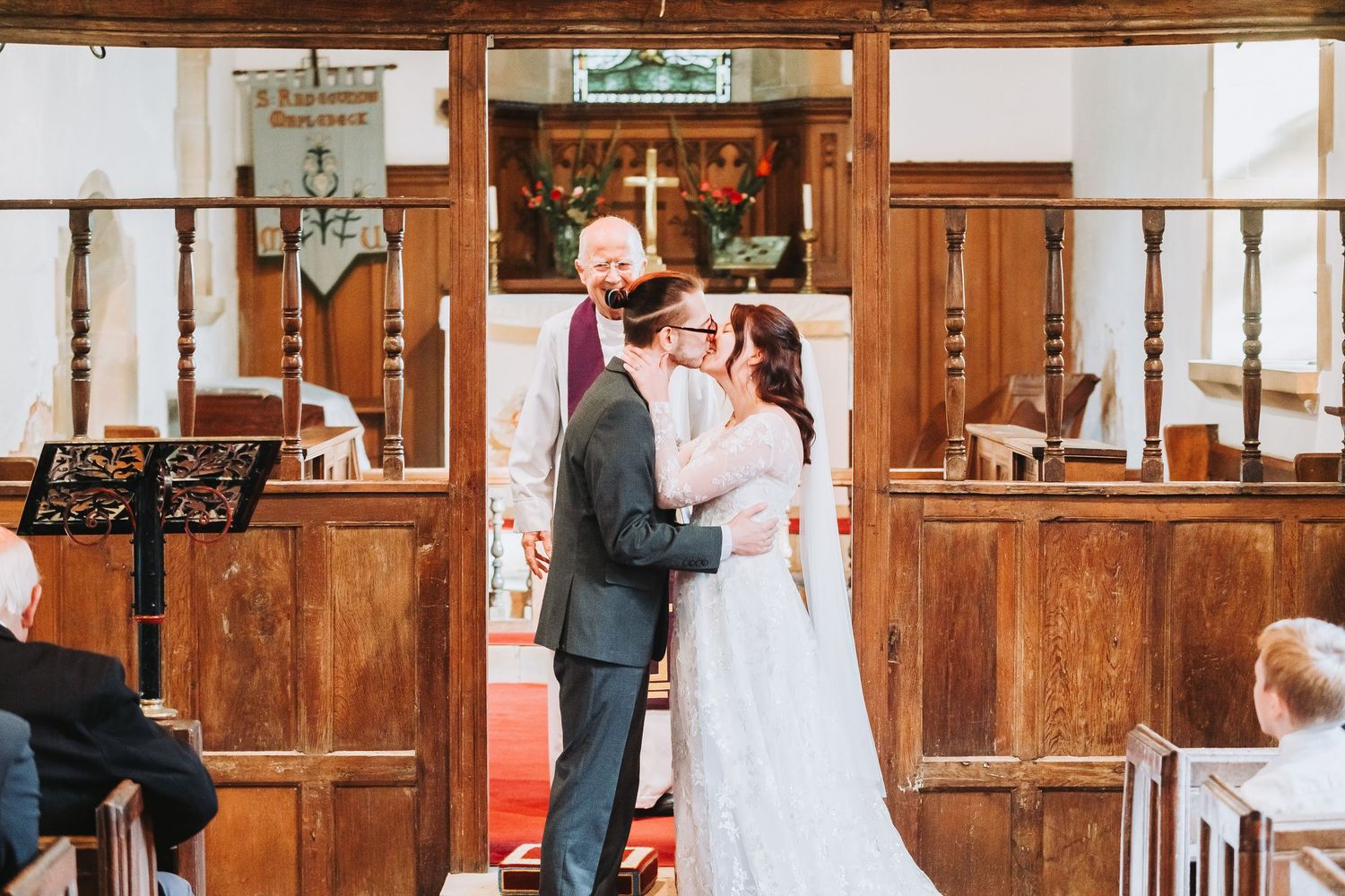 A couple shares an intimate moment in a rustic wooden interior during their wedding ceremony.