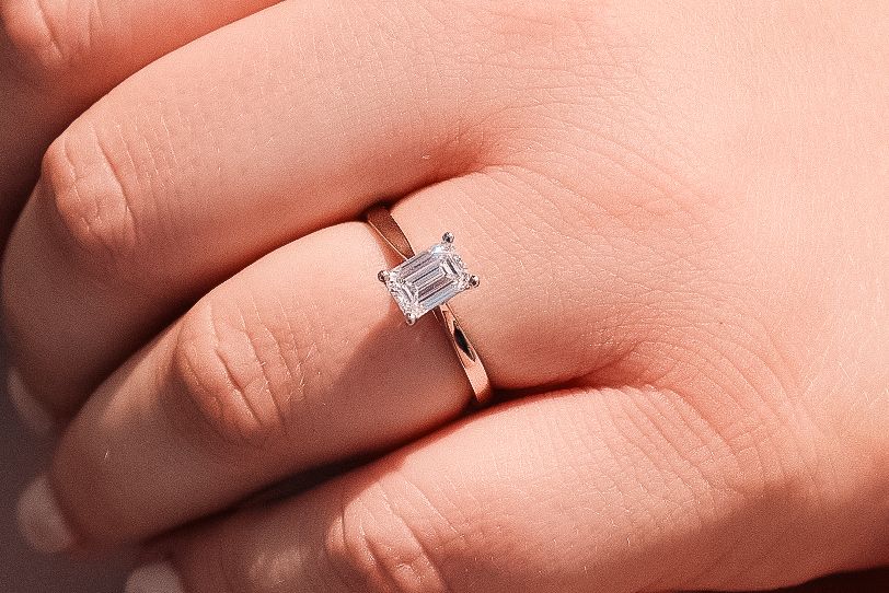 Close up macro shot of diamond engagement ring on finger.