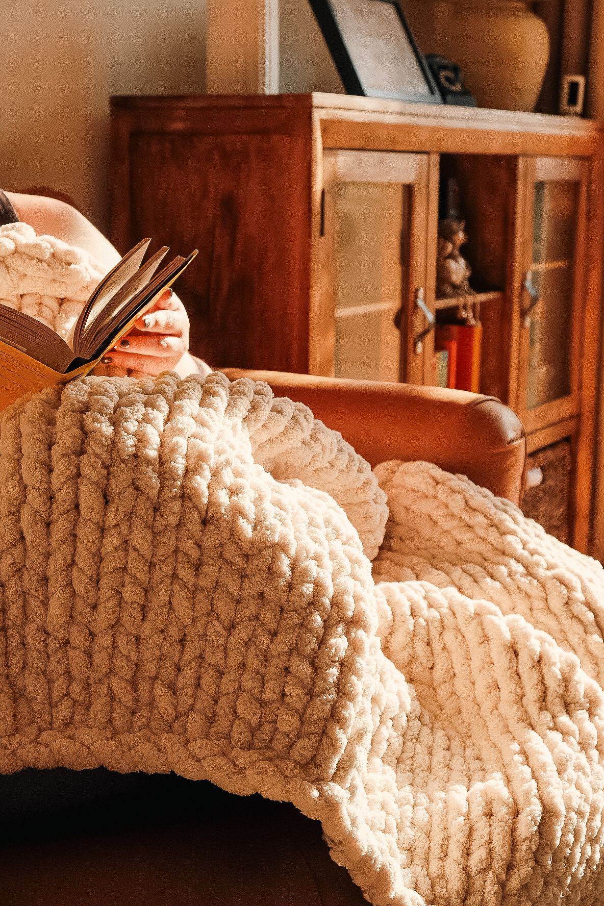 Close-up of chunky knit blanket with thick yarn texture against wooden furniture shot in Chesterfield by 21 Photography