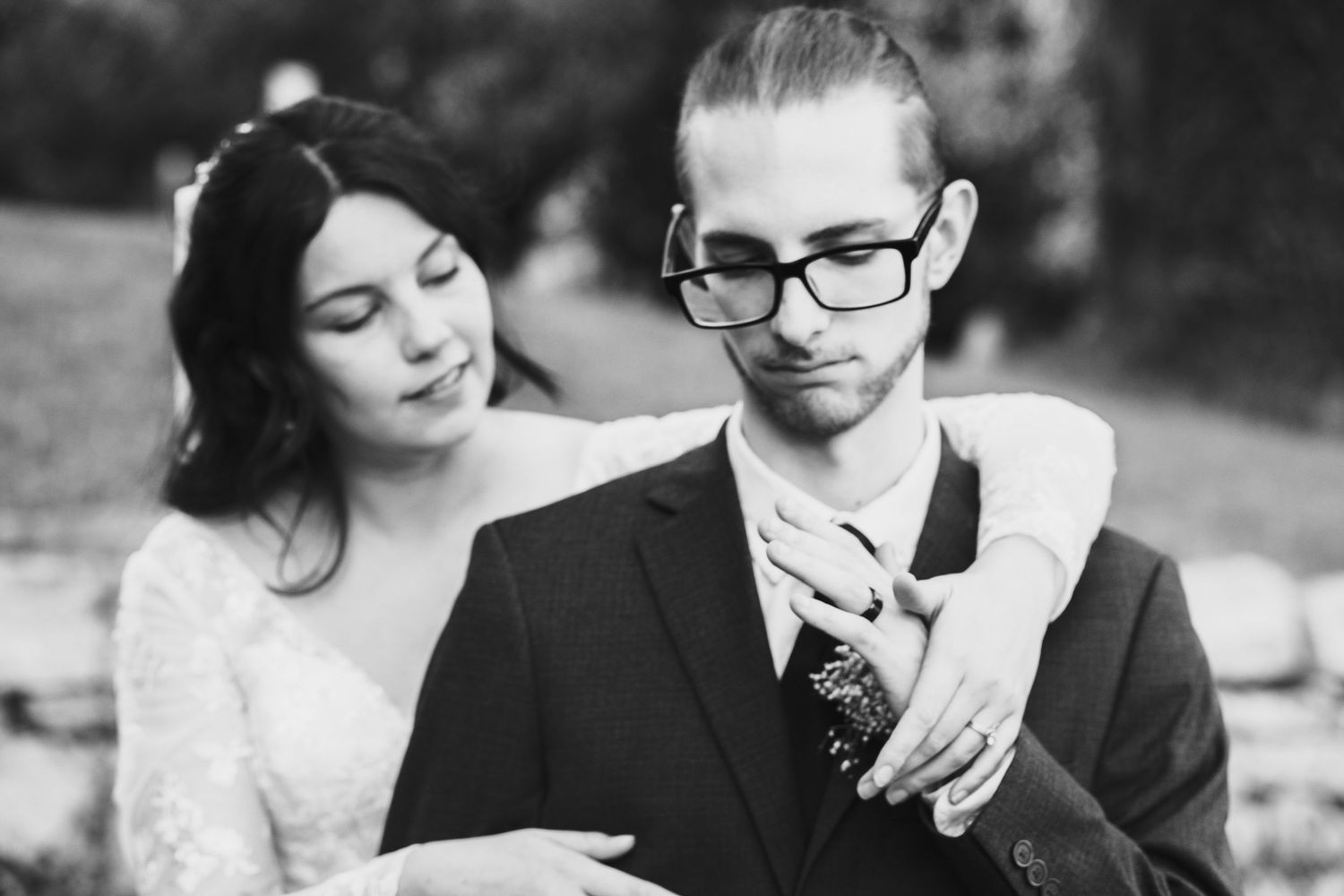 A romantic black and white wedding photo collage showing tender moments between newlyweds outdoors.