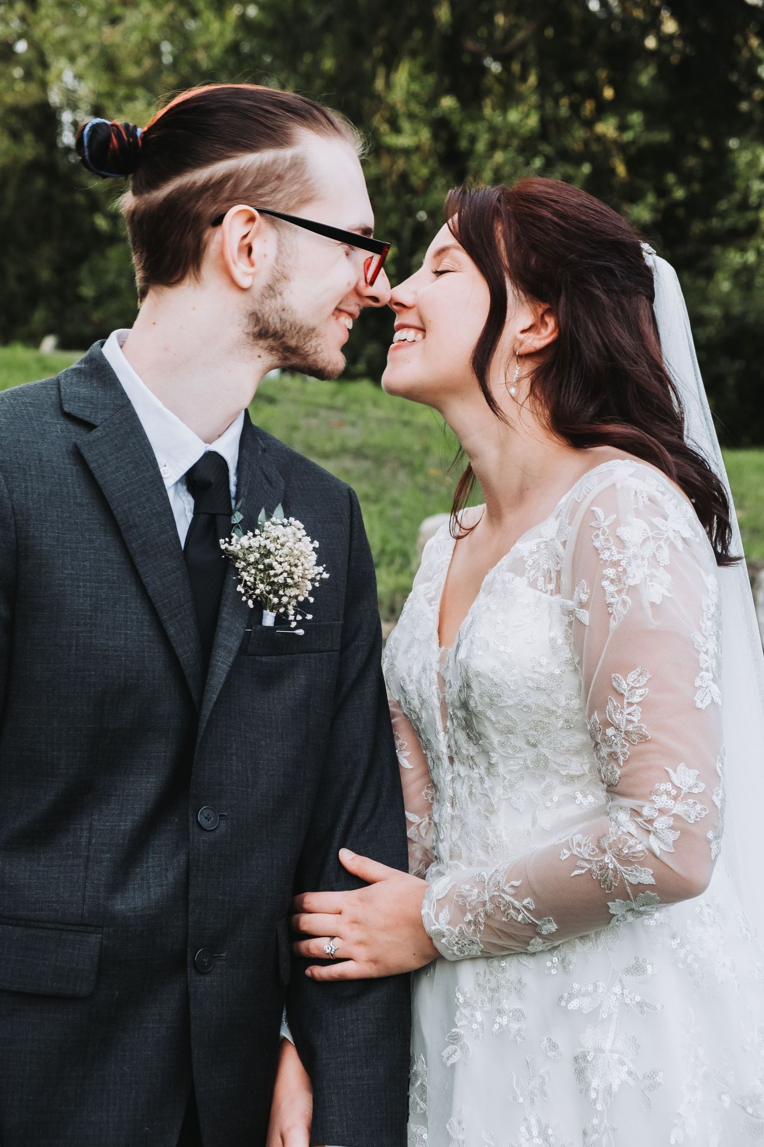 Romantic wedding couple sharing intimate moments against a garden backdrop.