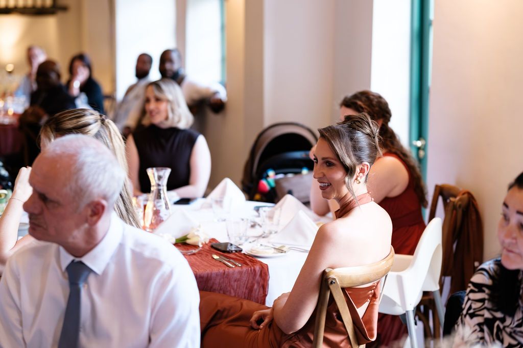 Bridesmaid glancing back over her shoulder at the dining table