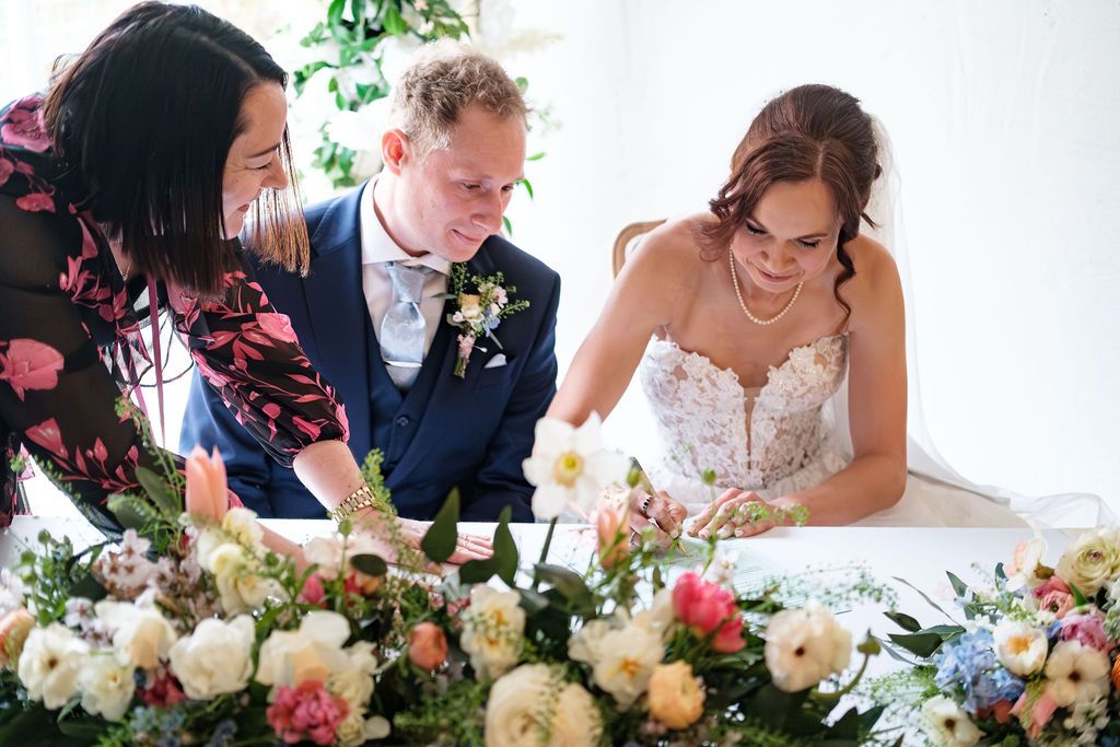 Bride and groom laughing together as register is being signed