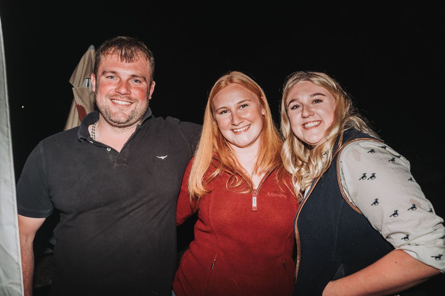 A nighttime celebration with people dressed casually posing together.