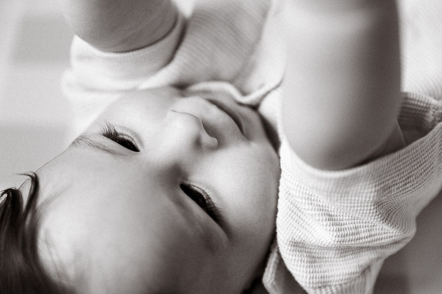 A collection of black and white close-up portrait photographs showing a baby in various peaceful poses.