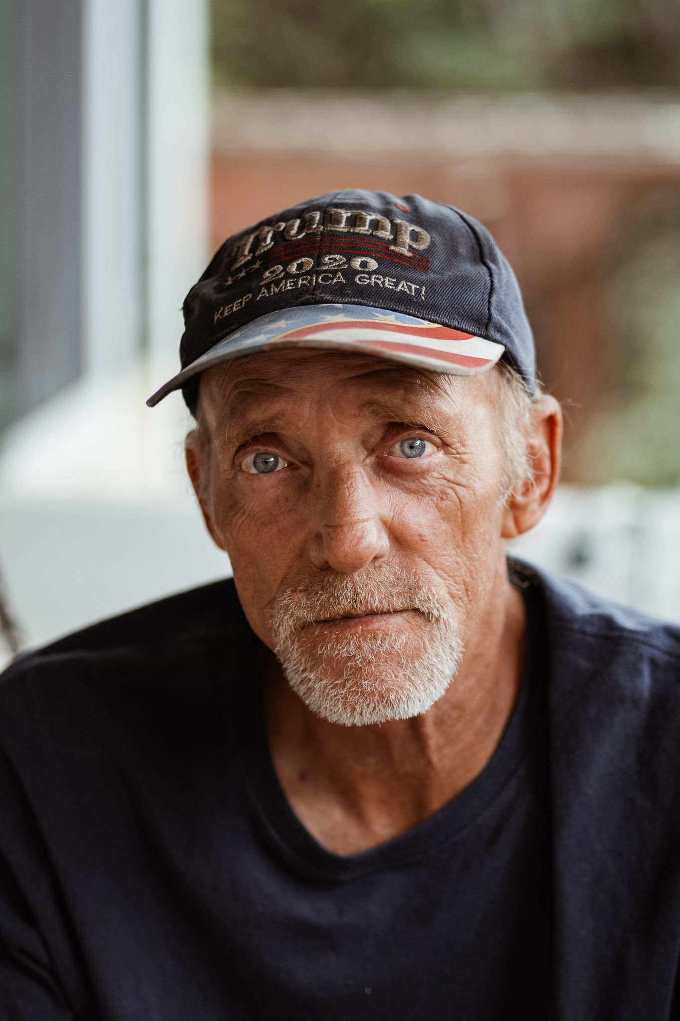 Portrait of person wearing black baseball cap with gray beard.