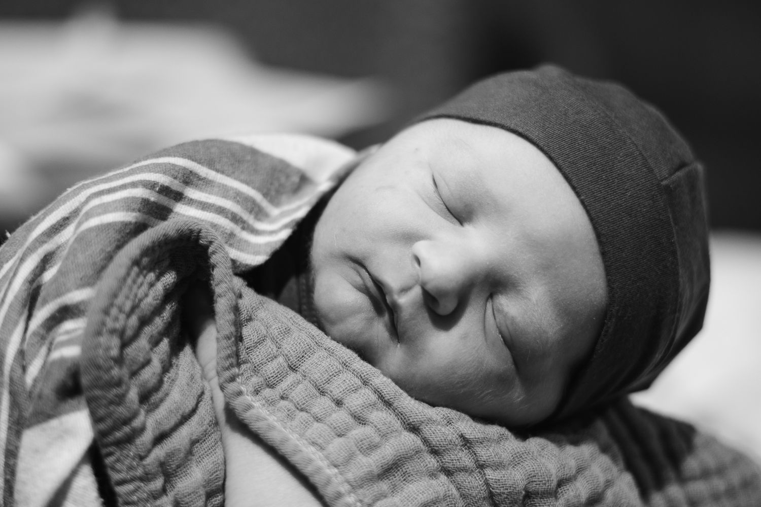 Peaceful sleeping newborn in black and white tones.