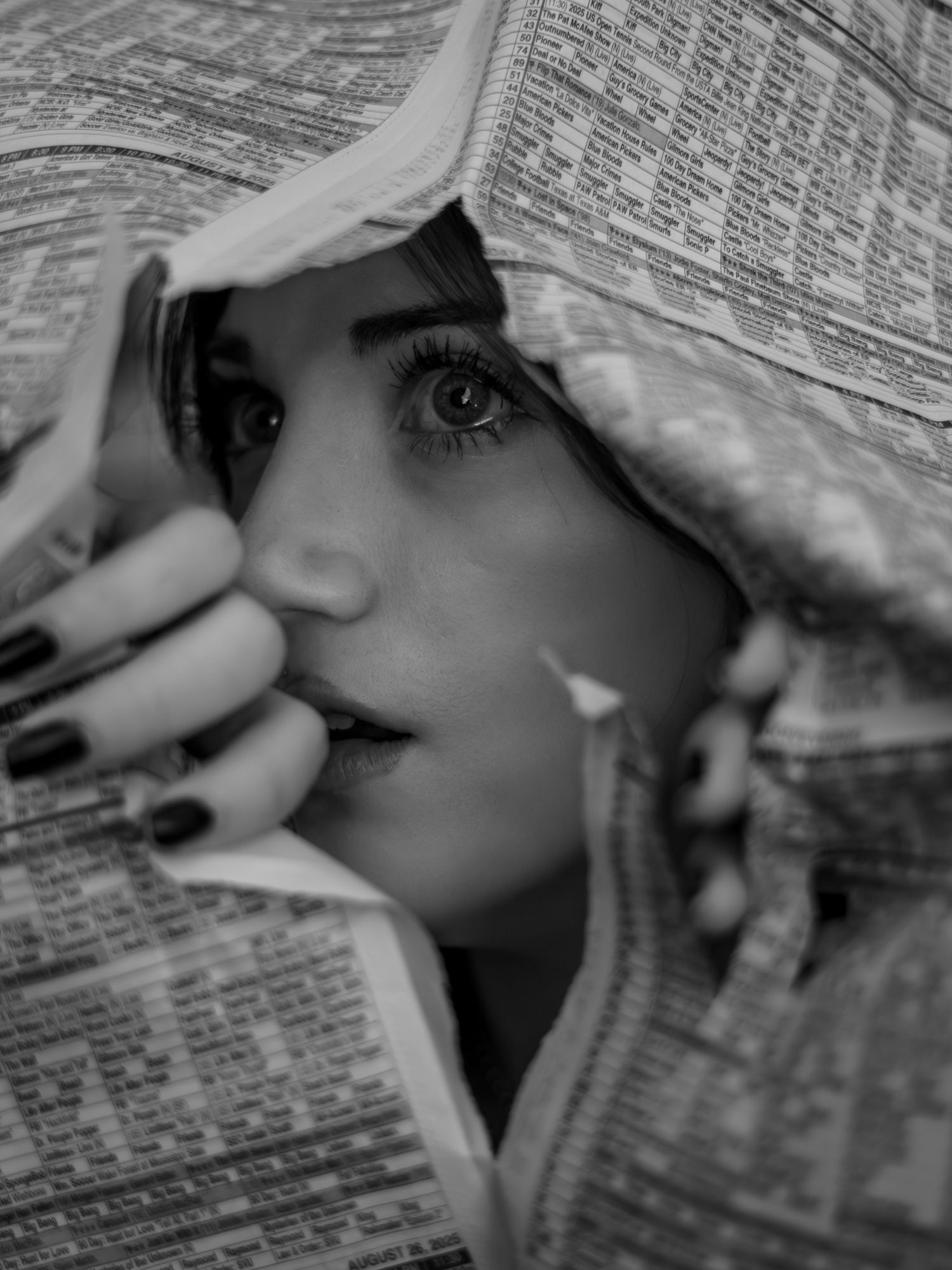 Black and white artistic portrait series showing someone peeking through newspaper pages with dramatic lighting and shadows.