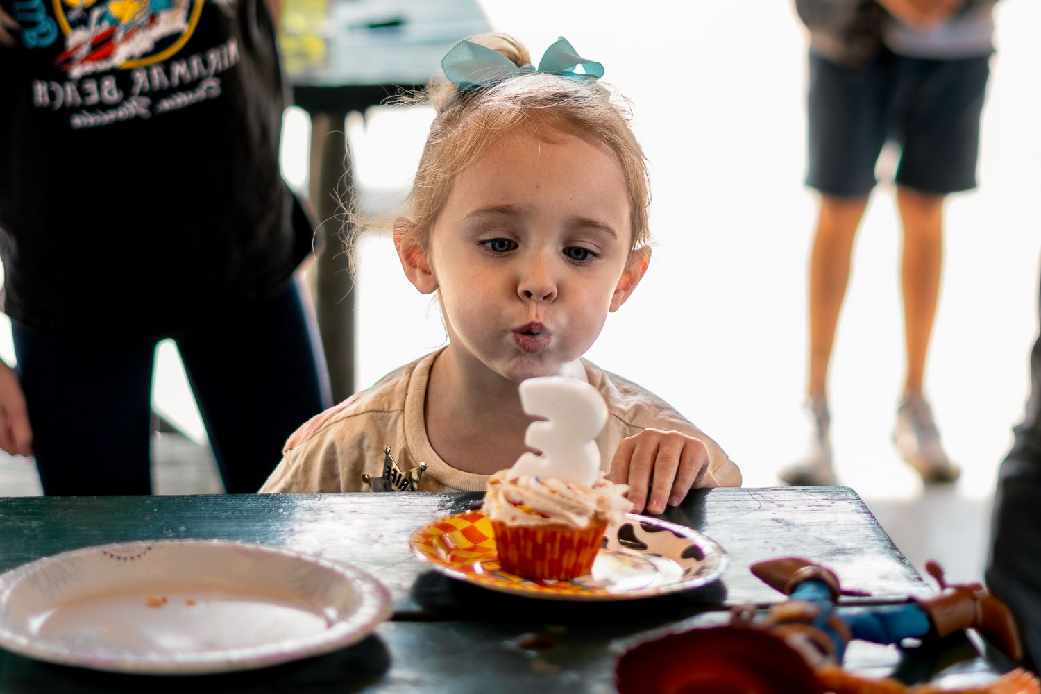 Child enjoying treats at a celebration table with festive decorations.