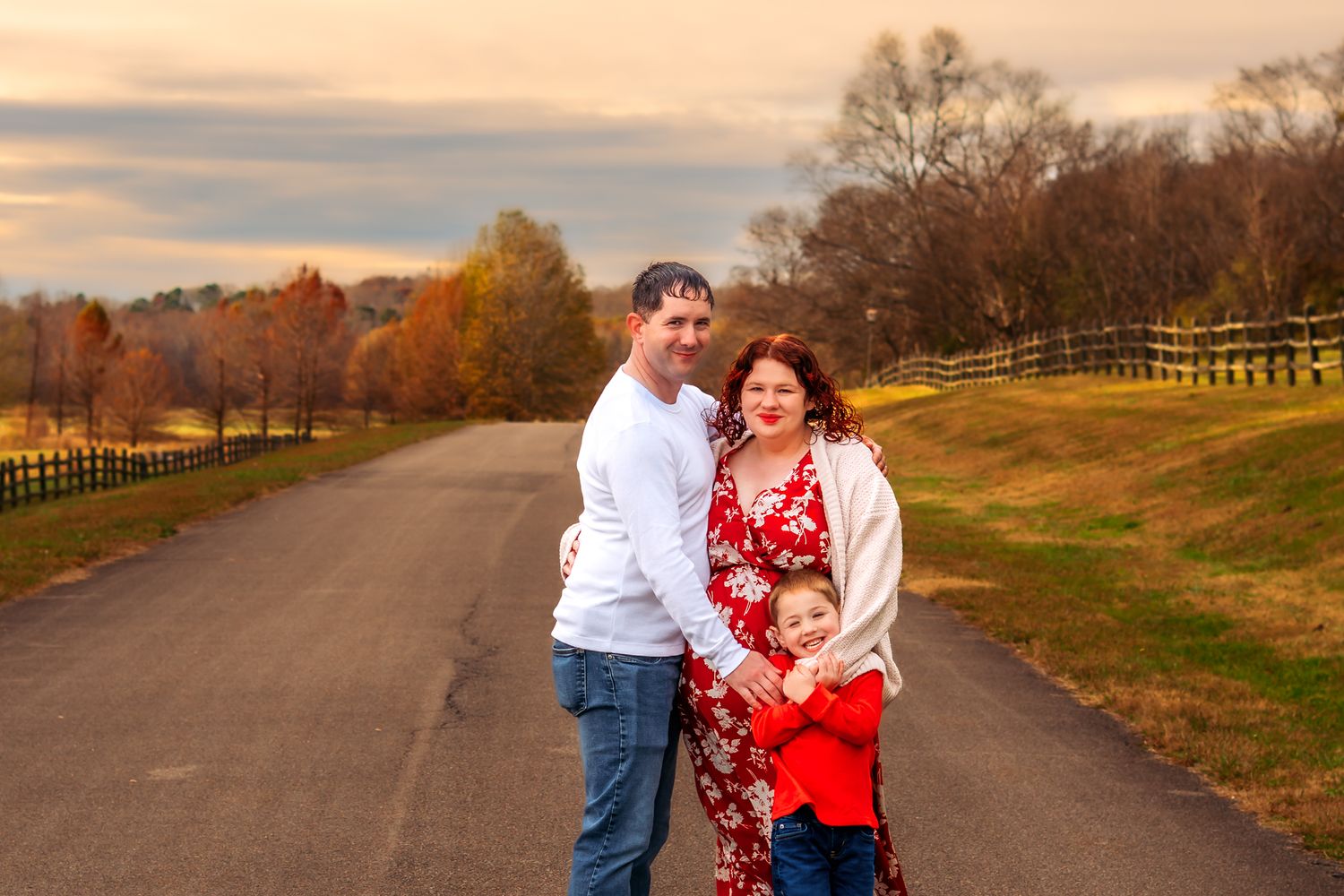 A couple walks and embraces along a scenic autumn path with golden fall foliage and warm sunset lighting.