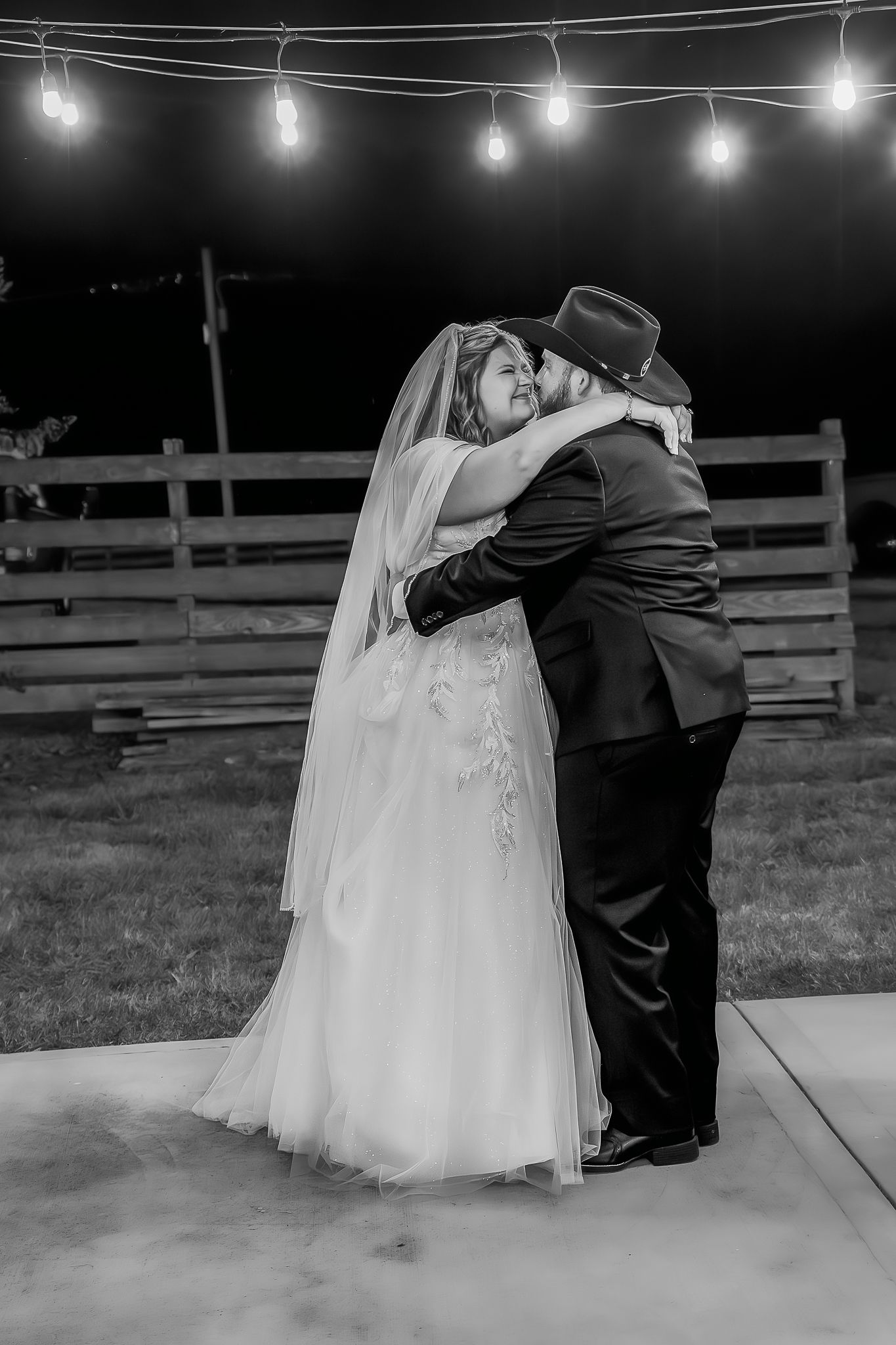 Evening wedding dance under string lights creating romantic ambiance.