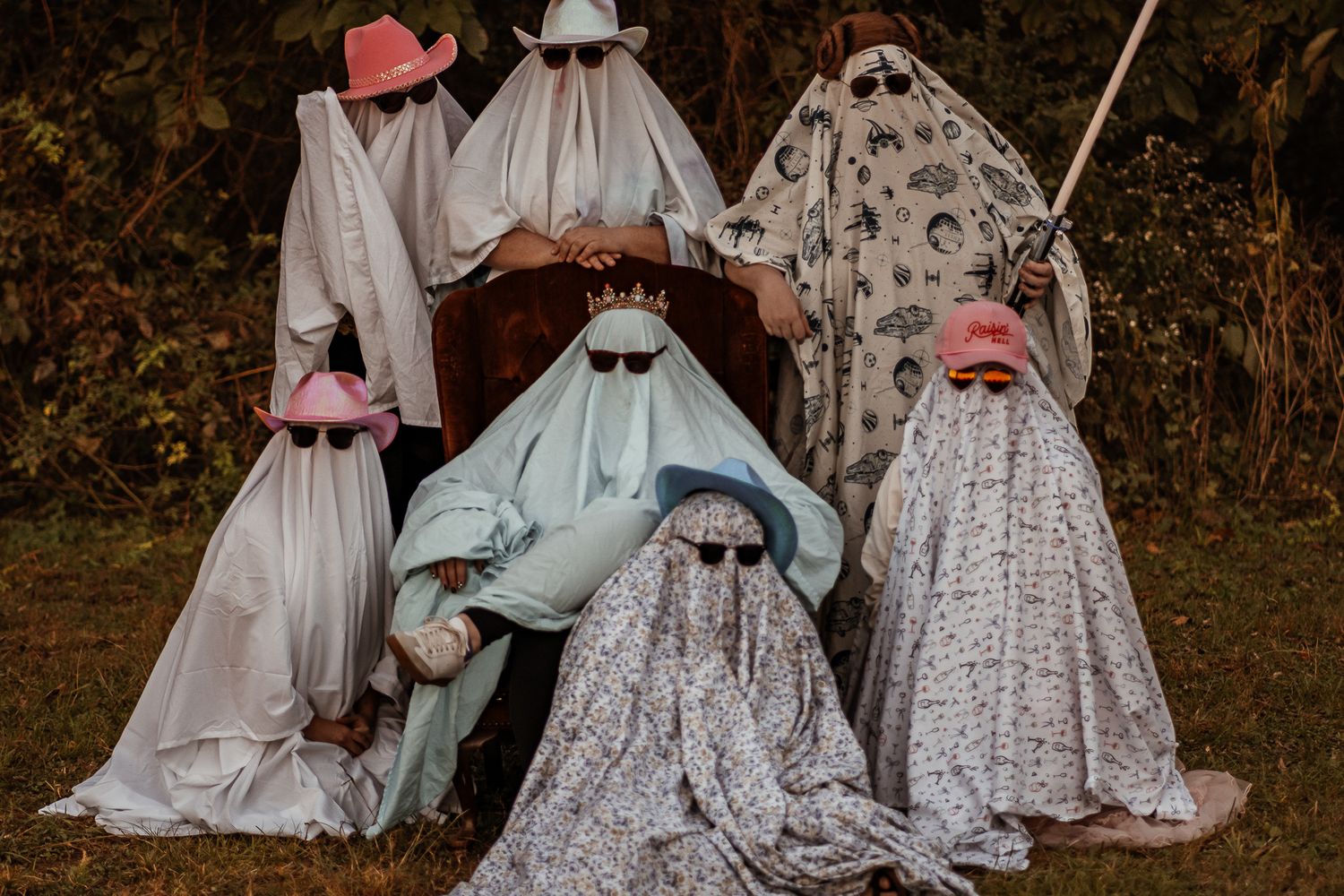 Whimsical Halloween display featuring ghost figures and skeletons in vintage-style clothing.