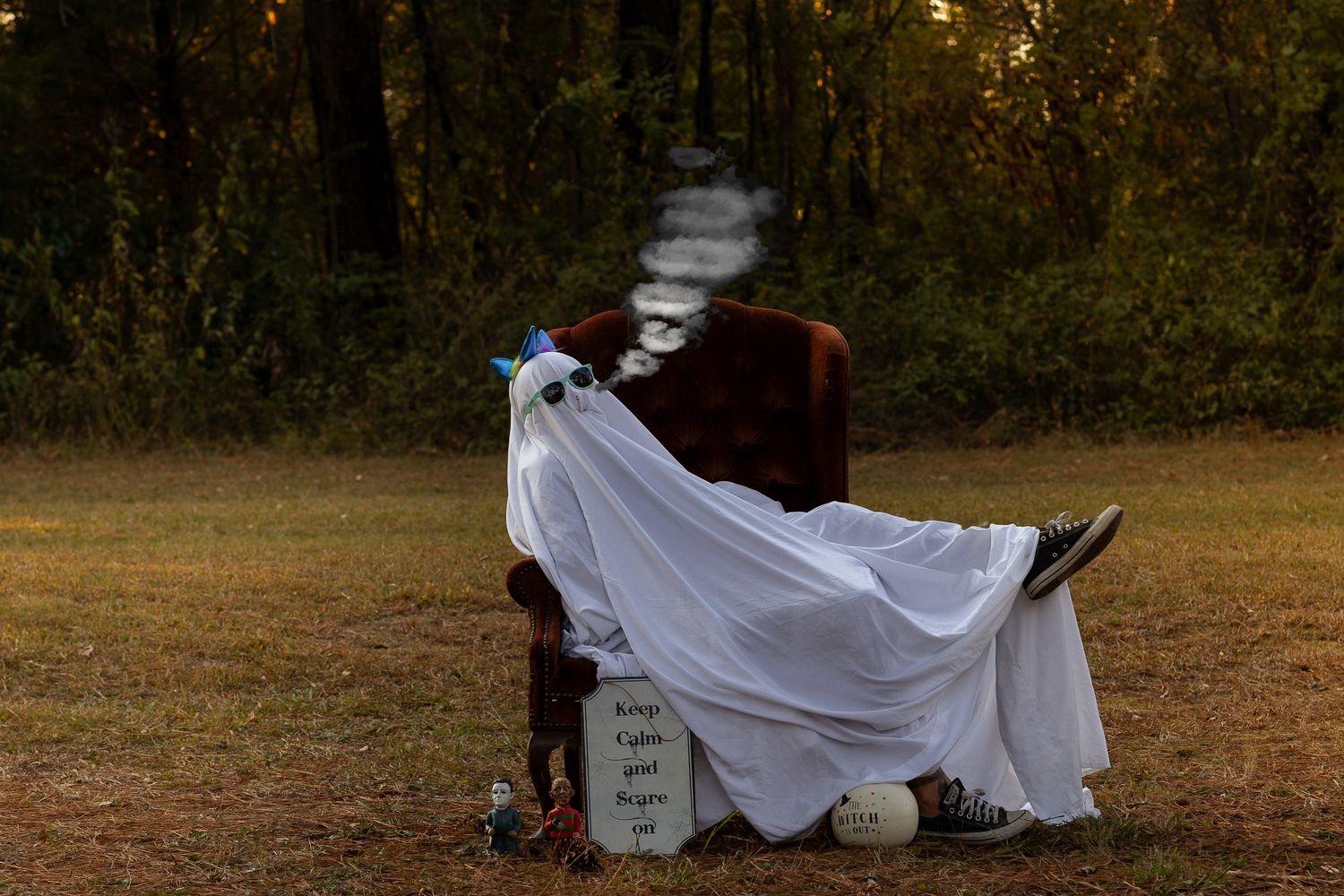 White ghostly figures arranged in an outdoor setting during golden hour.