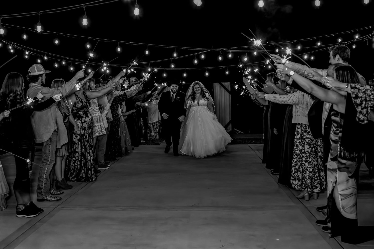 Wedding exit with sparklers creating magical nighttime atmosphere.