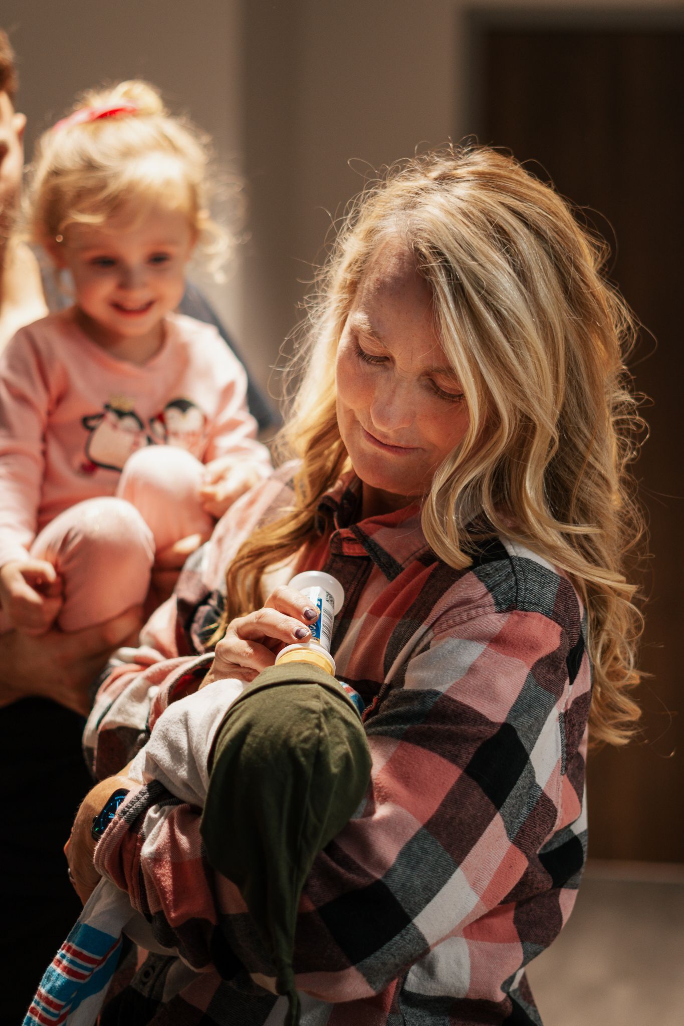 A tender moment showing affection with a plaid shirt and pink clothing.