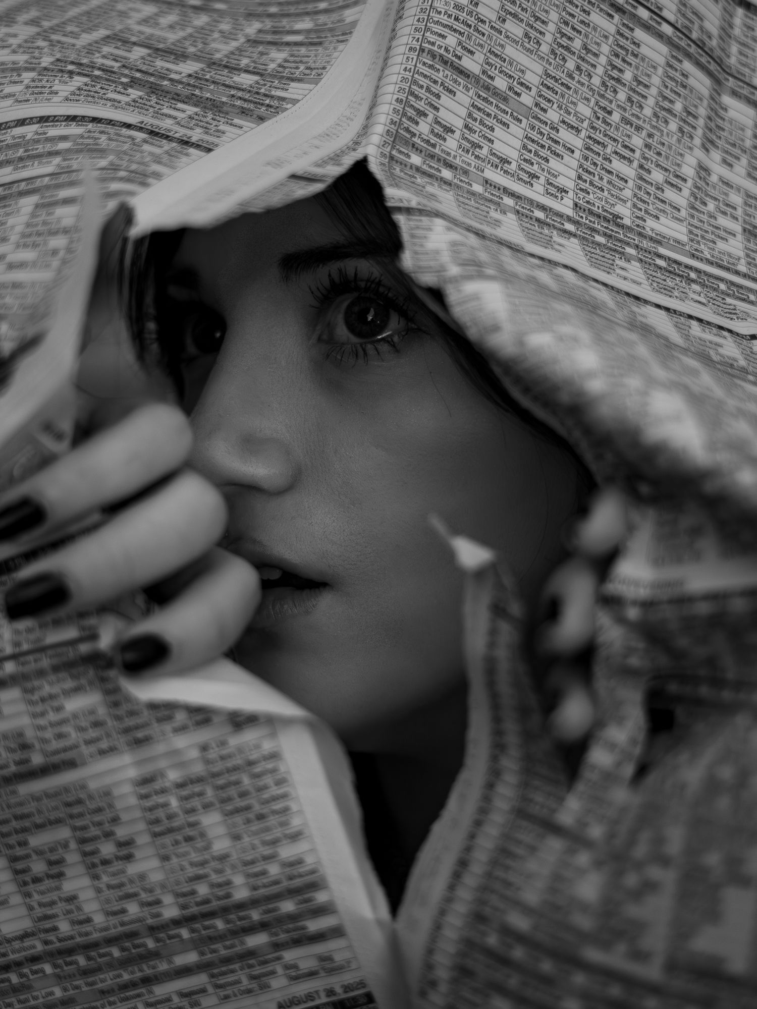 Dramatic black and white close-up photo of eye peeking through book pages.