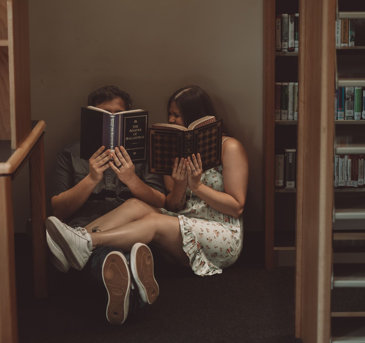 A romantic library photoshoot featuring books and intimate moments between shelves.