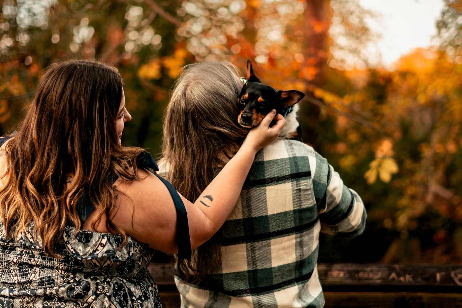 Two people taking photos on a bridge during a golden autumn afternoon.