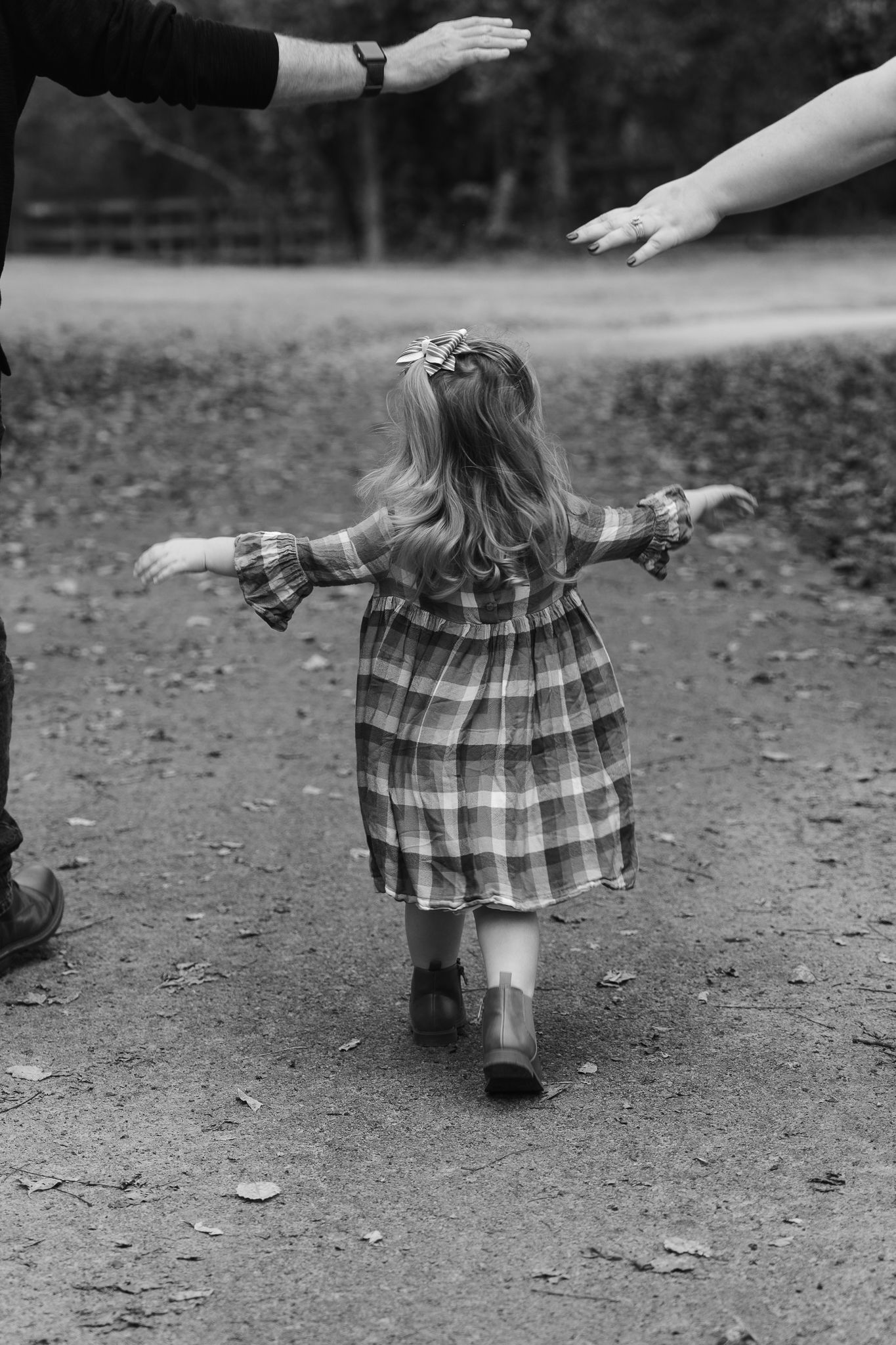 Black and white sequence showing a plaid dress twirling on a dirt path covered in fallen leaves.