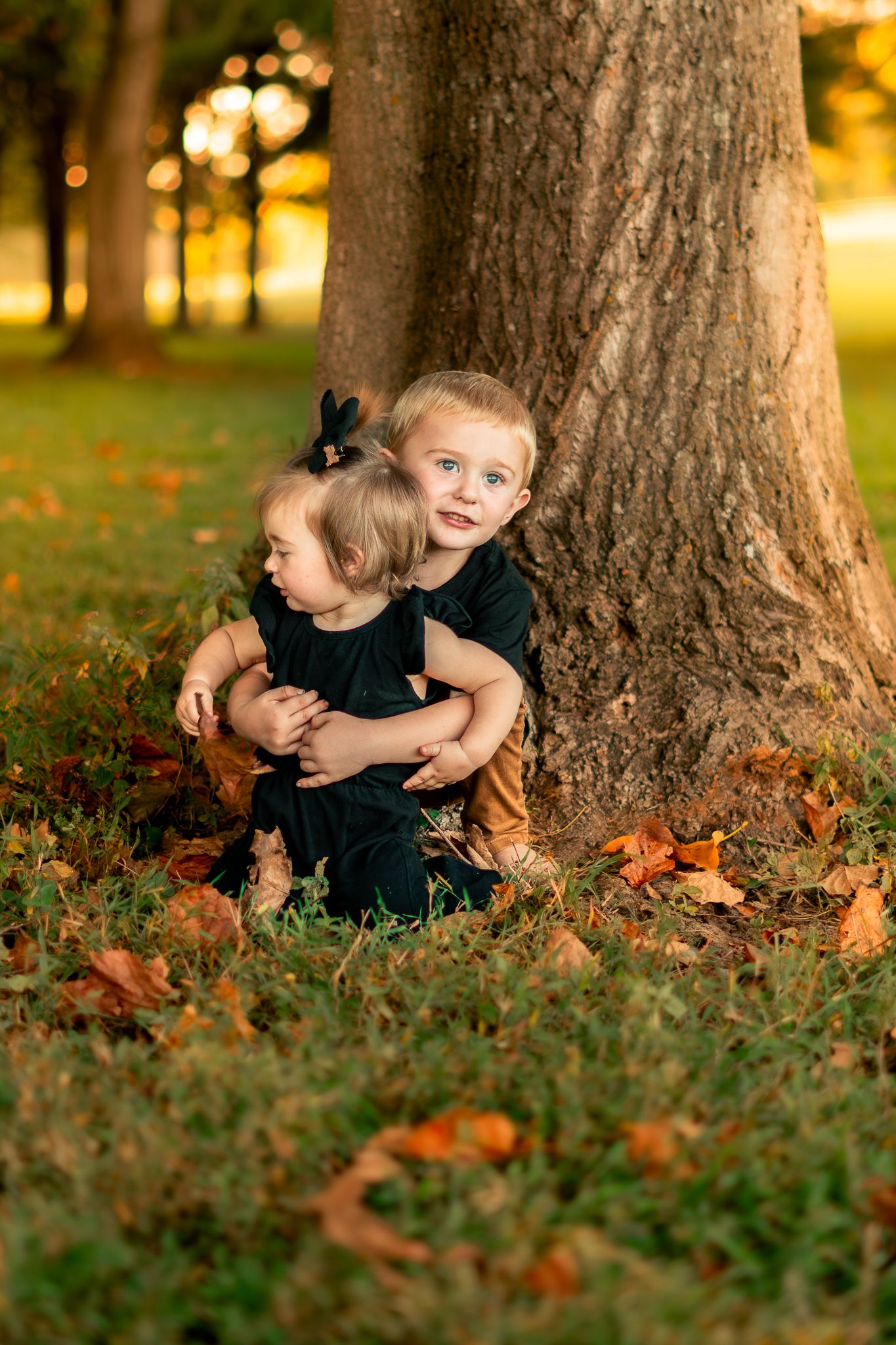 Three sequential photos show a child playing in autumn leaves near a tree trunk at golden hour.