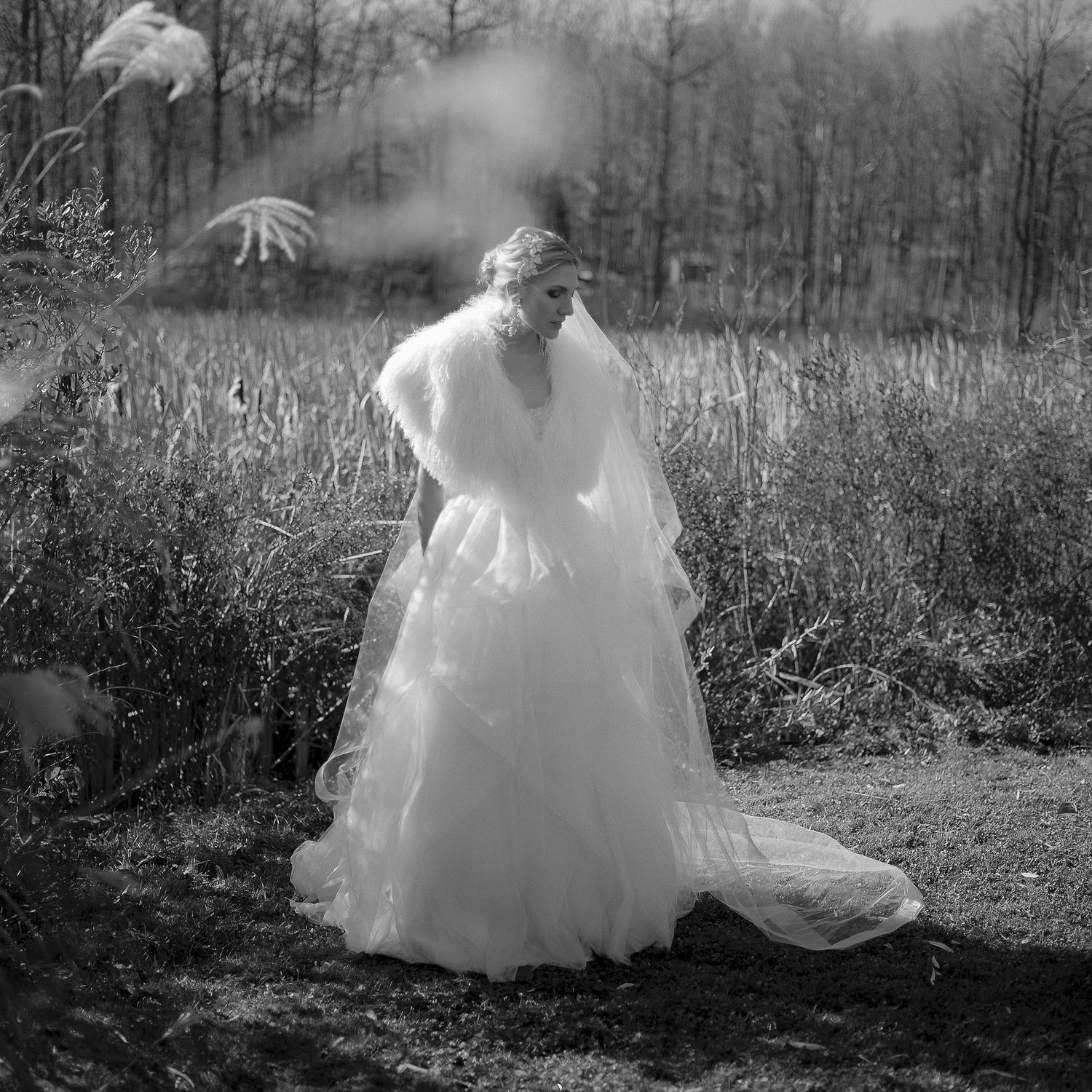A romantic black and white photo sequence showing a couple in a wedding dress and suit walking through a natural outdoor setting.