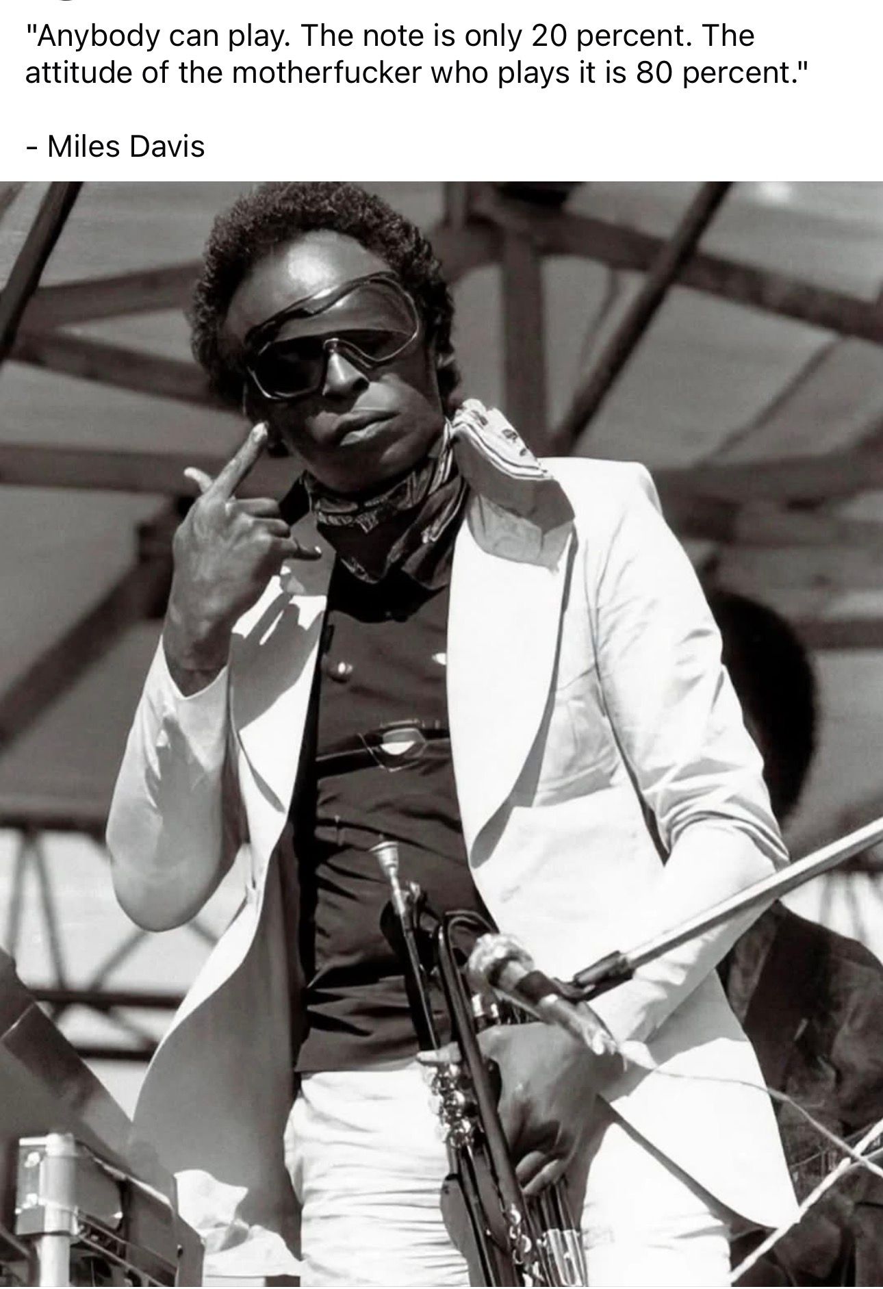 Black and white photo of Miles Davis in sunglasses and white suit, giving middle finger, with famous attitude quote overlay.