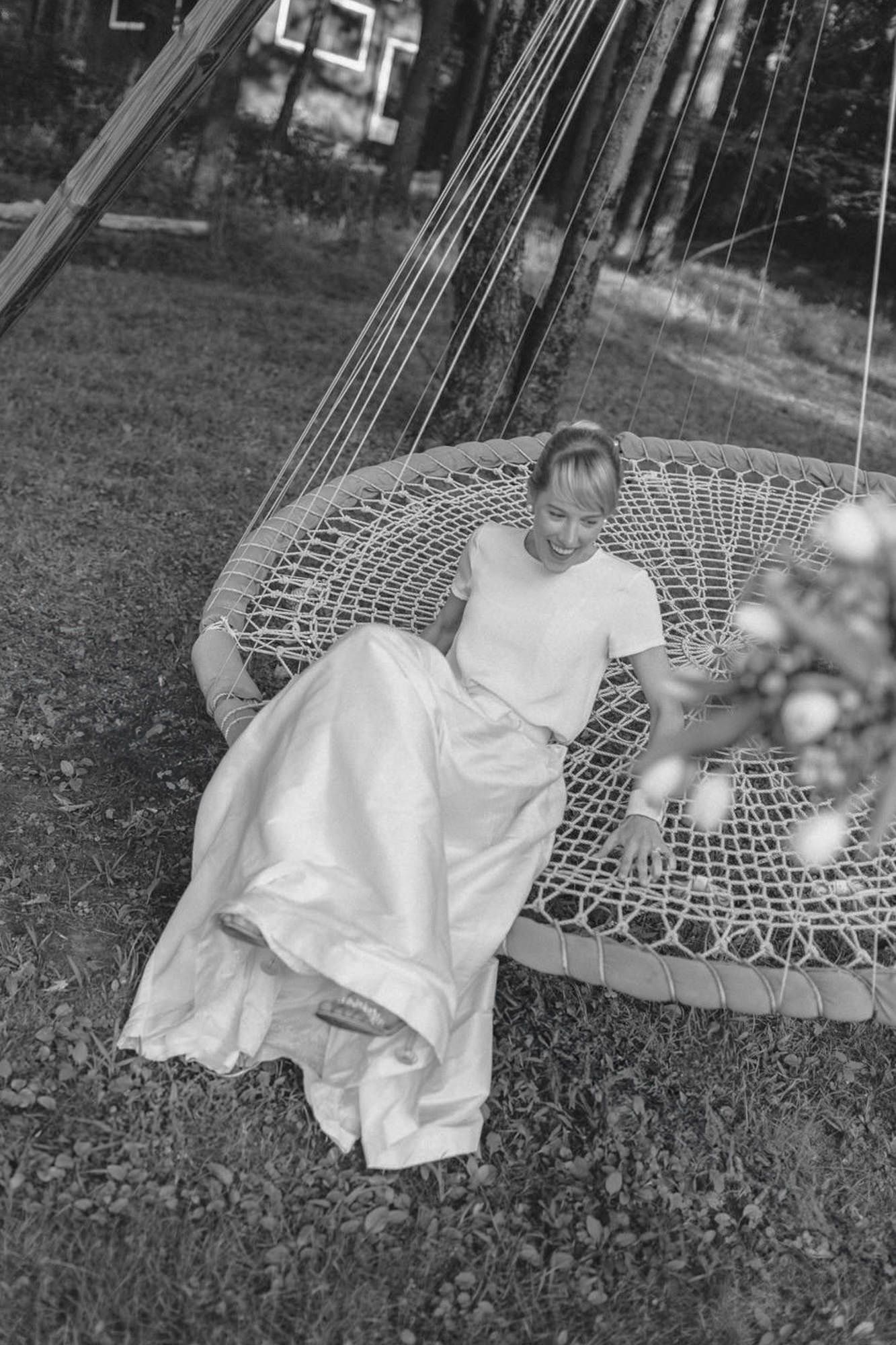 Series of black and white photos showing someone relaxing in a woven peacock chair outdoors.