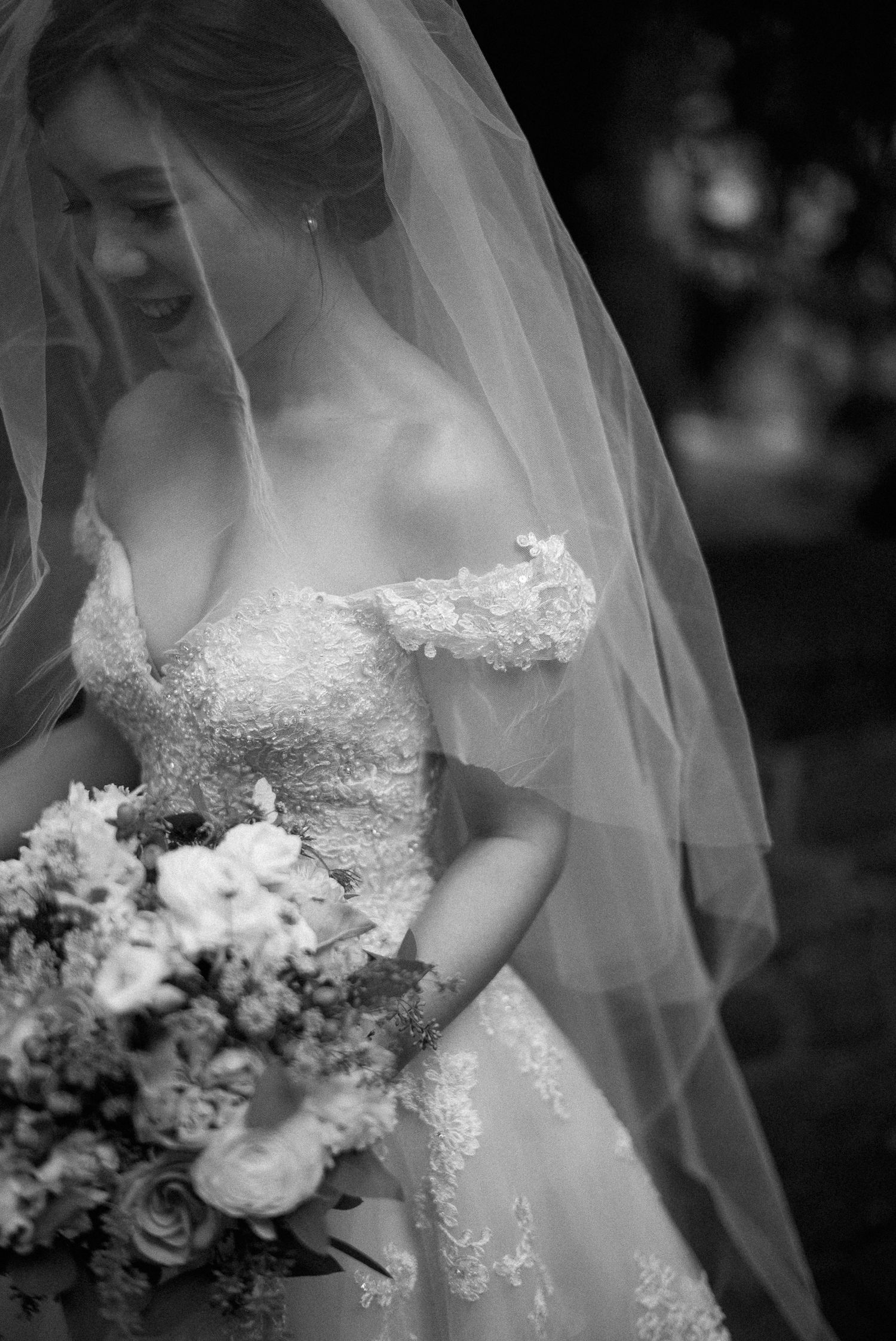 Black and white bridal portrait series showing wedding dress details, veil, and floral bouquet in soft focus.