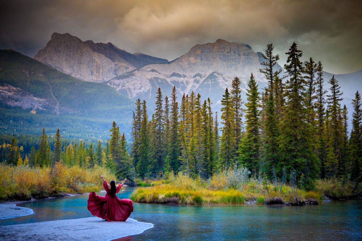 Mountain lake surrounded by evergreen forest during golden hour.