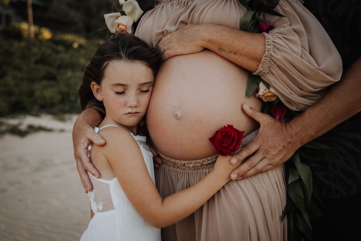 Intimate maternity photography session showing gentle embraces and baby bump silhouettes against a natural backdrop.
