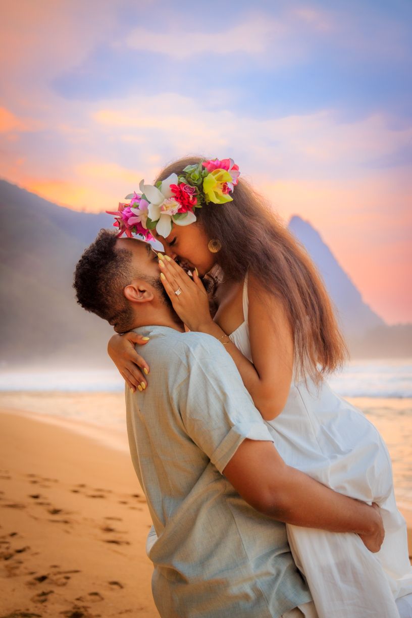 A romantic sunset beach moment with flower crowns and golden sky.