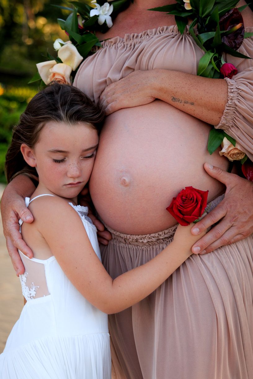 Artistic maternity photo series featuring floral elements and soft lighting.