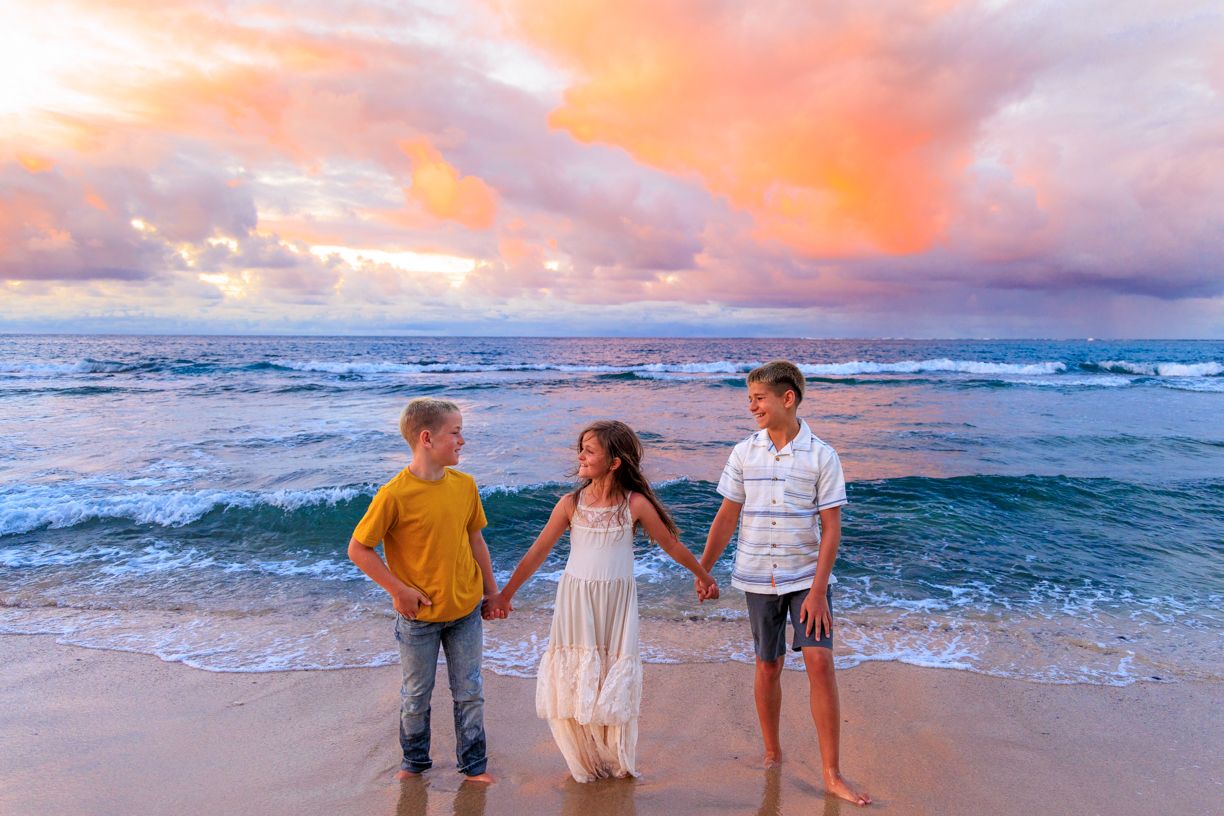 People watching dramatic sunset over ocean waves.