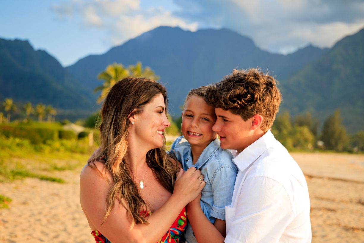 A loving family moment captured against mountain backdrop in Hawaii.