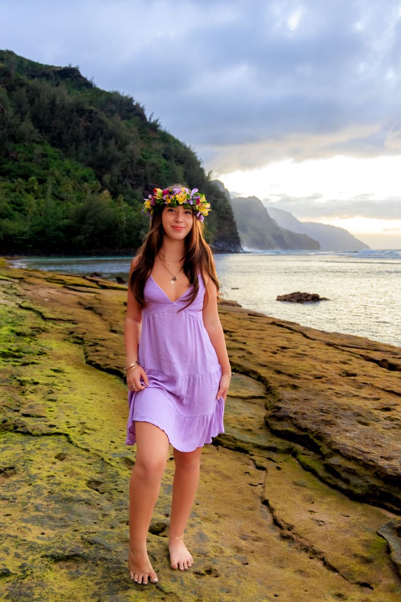 Scenic Hawaiian coastline with mountains and ocean views at sunset.