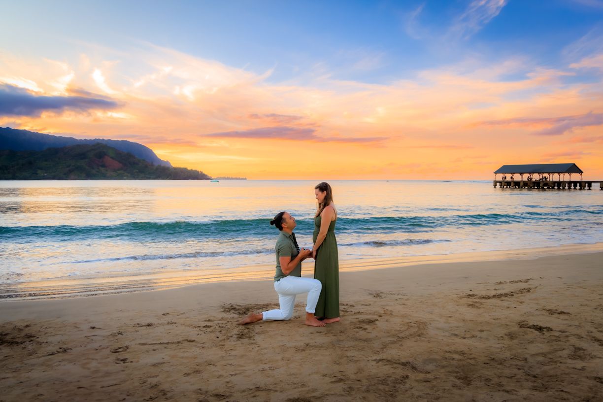 Panoramic beach sunset with mountains and pier in Kauai, Hawaii.