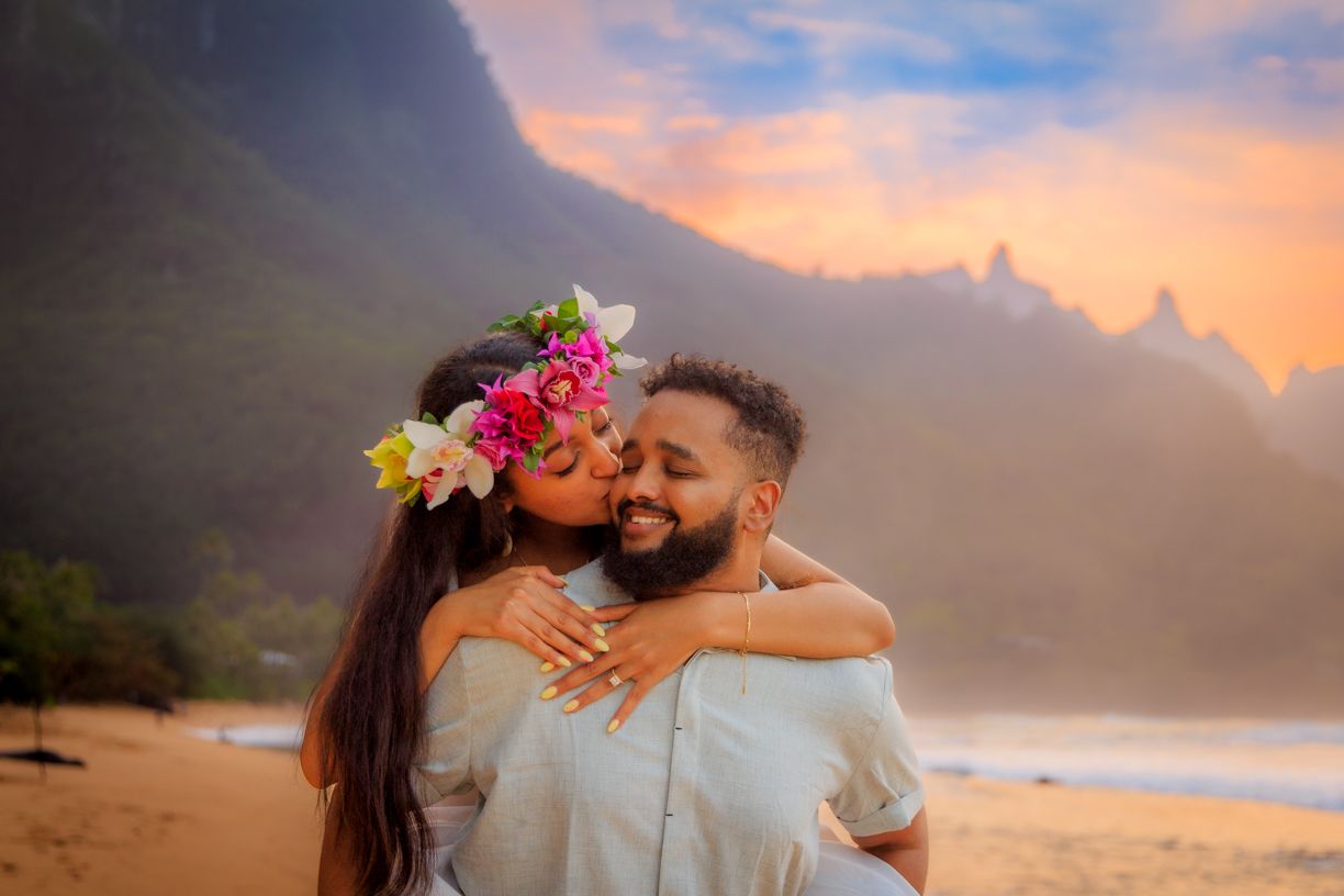 Romantic beach photoshoot during a vibrant orange Hawaiian sunset.