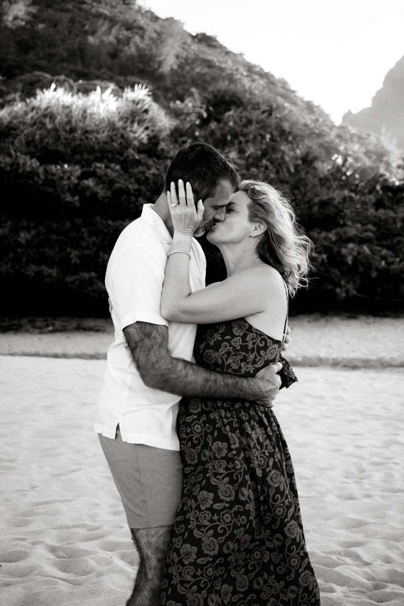 A romantic couple shares tender moments on a beach with mountains in the background during a photo sequence.