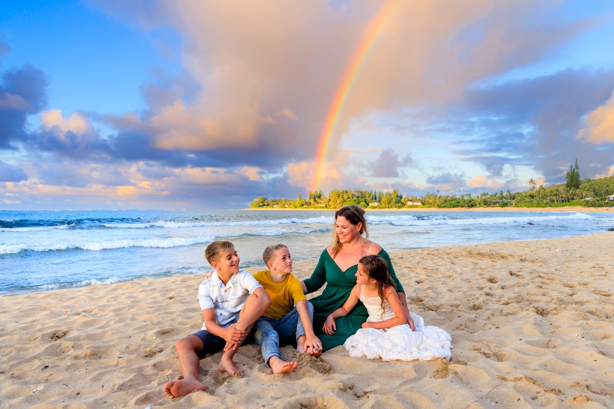Beautiful rainbow appears over Hawaiian beach during sunset photo session.