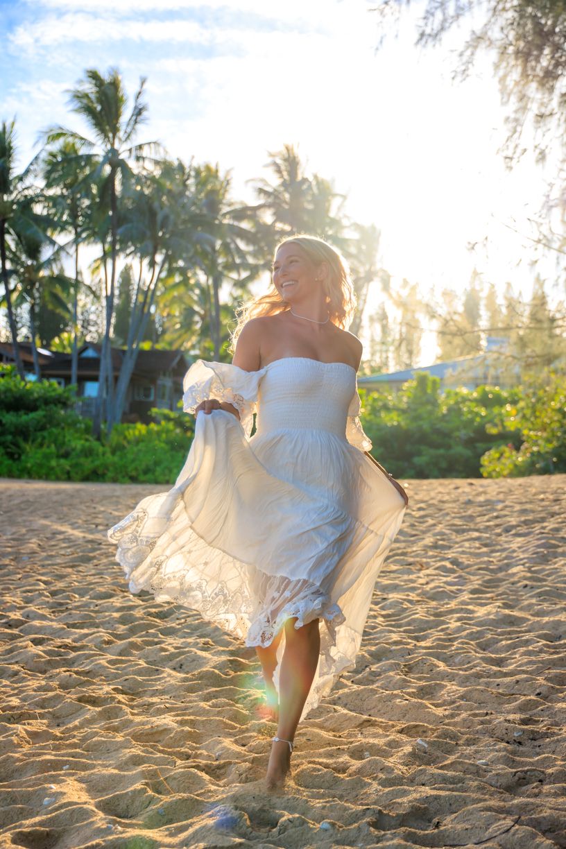 Ethereal white dress movement captured on tropical beach at sunset with swaying palms.