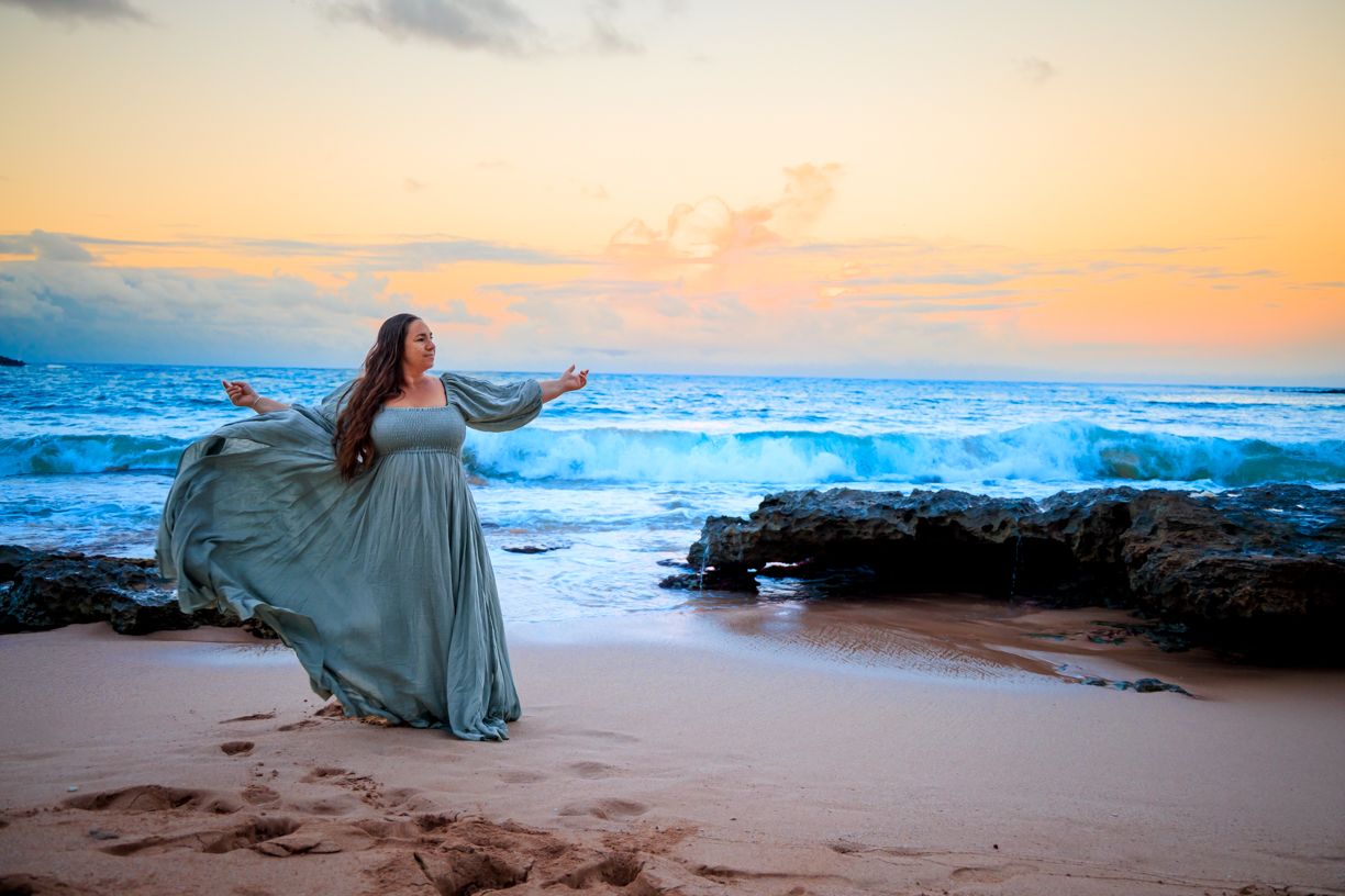 Ethereal beach scene at sunset with waves crashing against rocky shore.