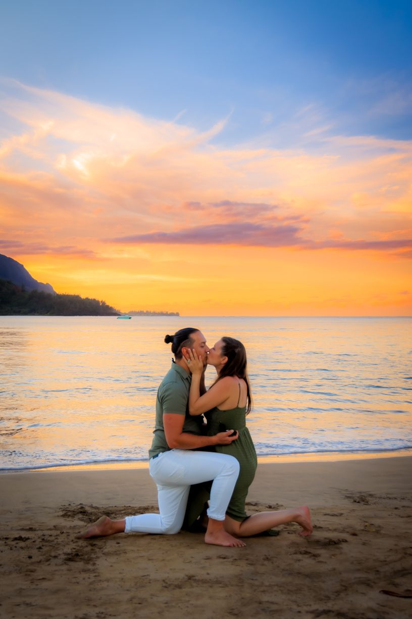 Romantic beach proposal during golden sunset with ocean waves.