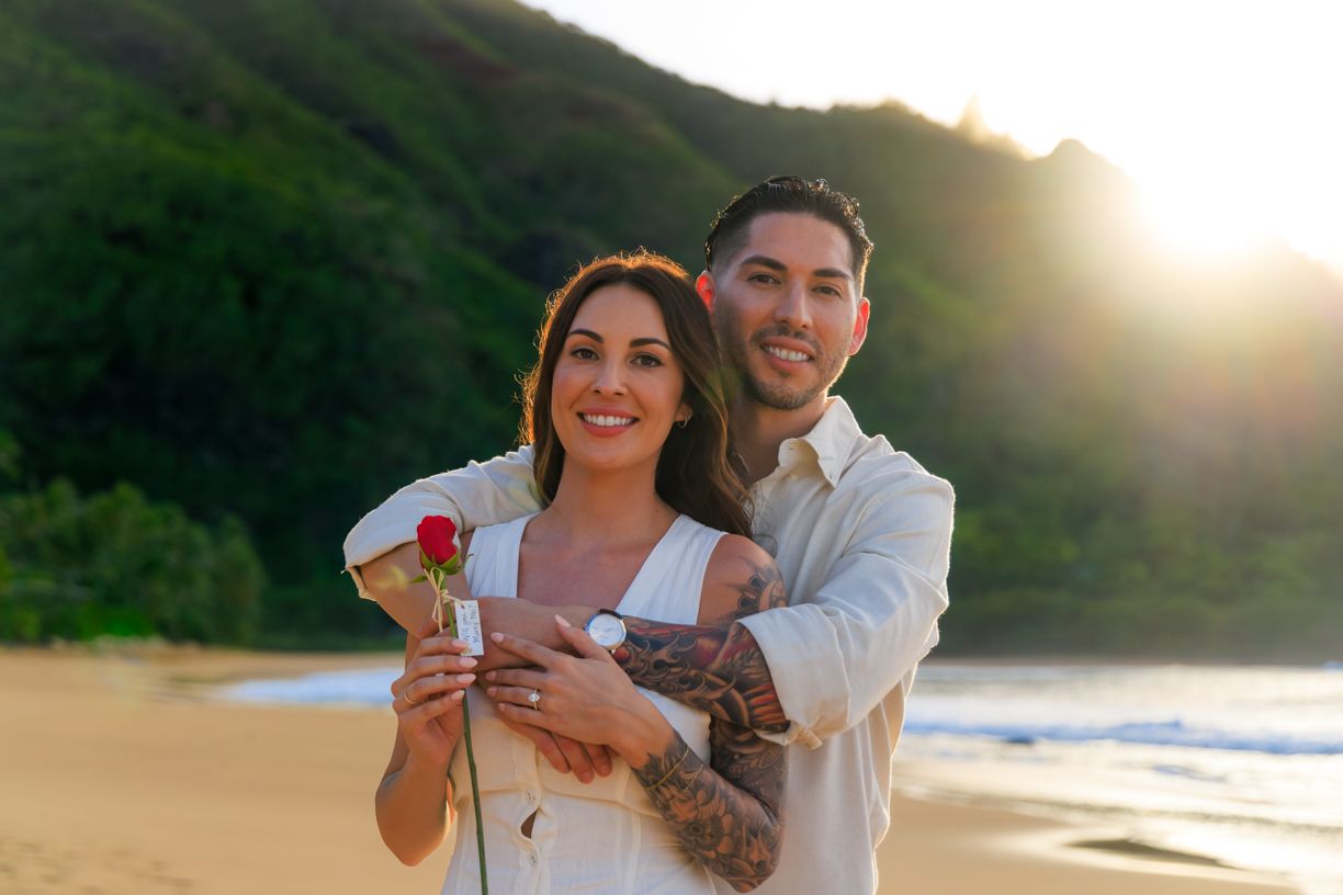 Happy couple sharing a romantic moment on a tropical beach at golden hour.