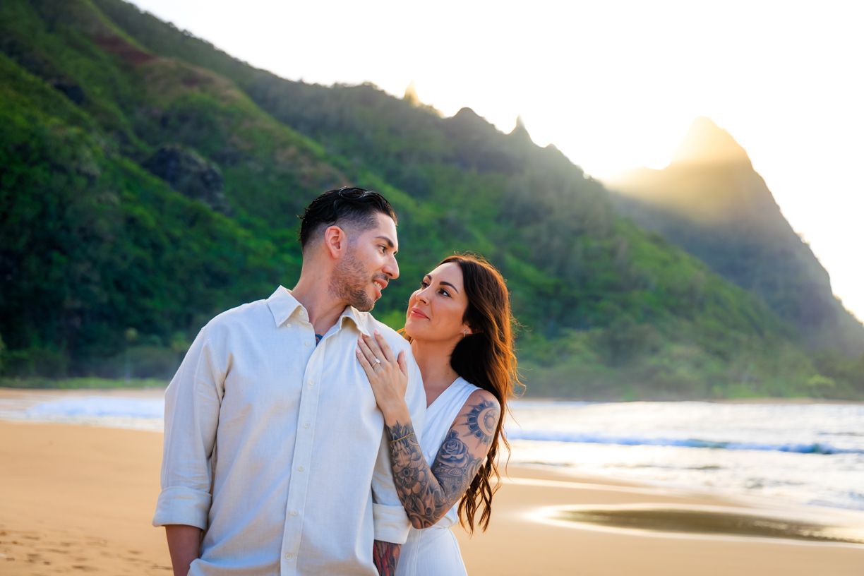 Romantic beach photos with golden sunset and mountain backdrop.