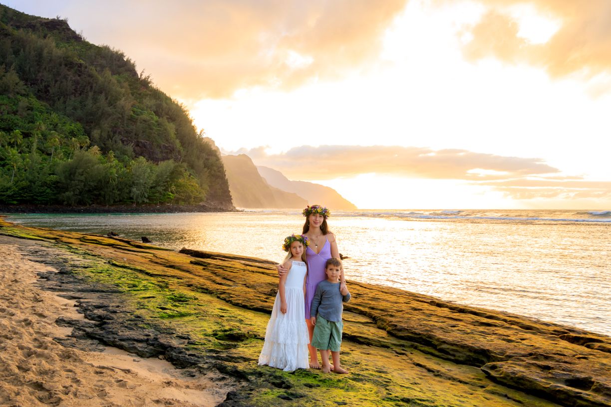 Scenic coastal landscape at sunset with dramatic cliffs and golden light reflecting off the ocean.