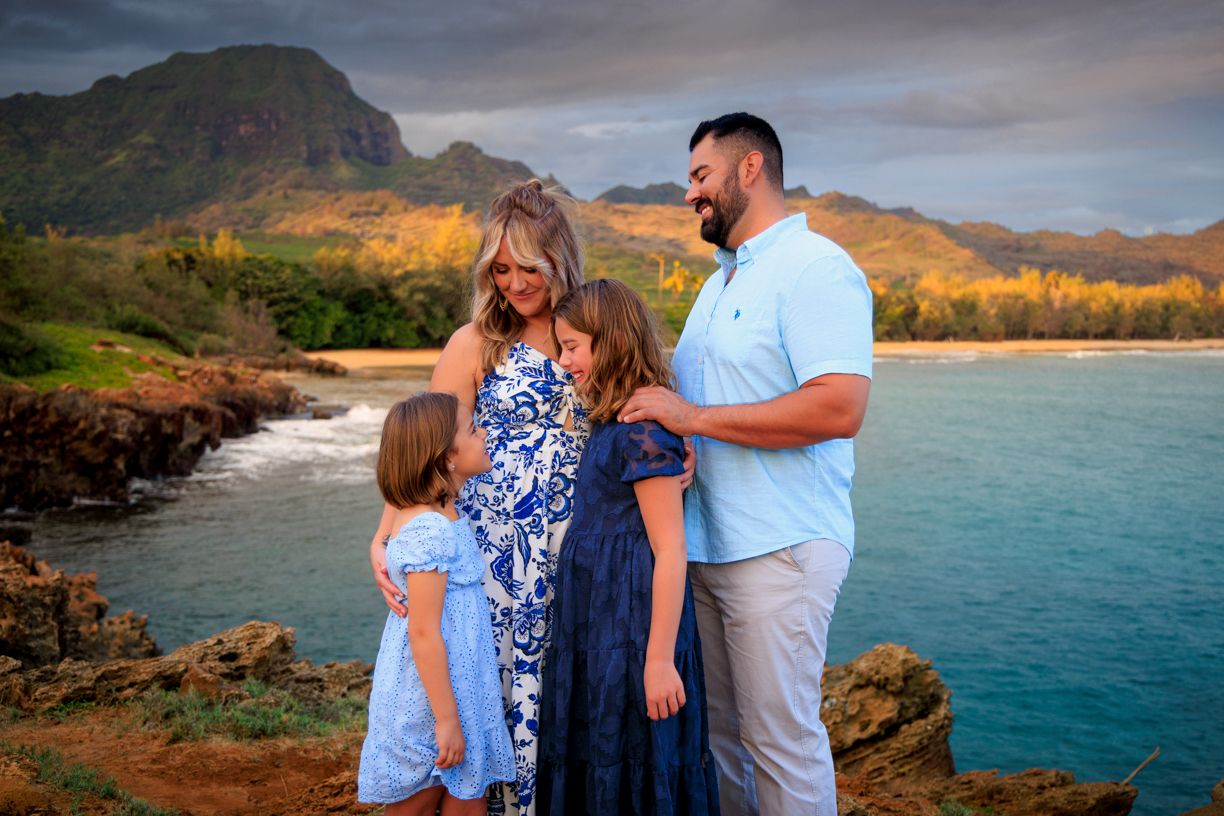 Family shares emotional moments together with mountains and ocean views in Hawaii.