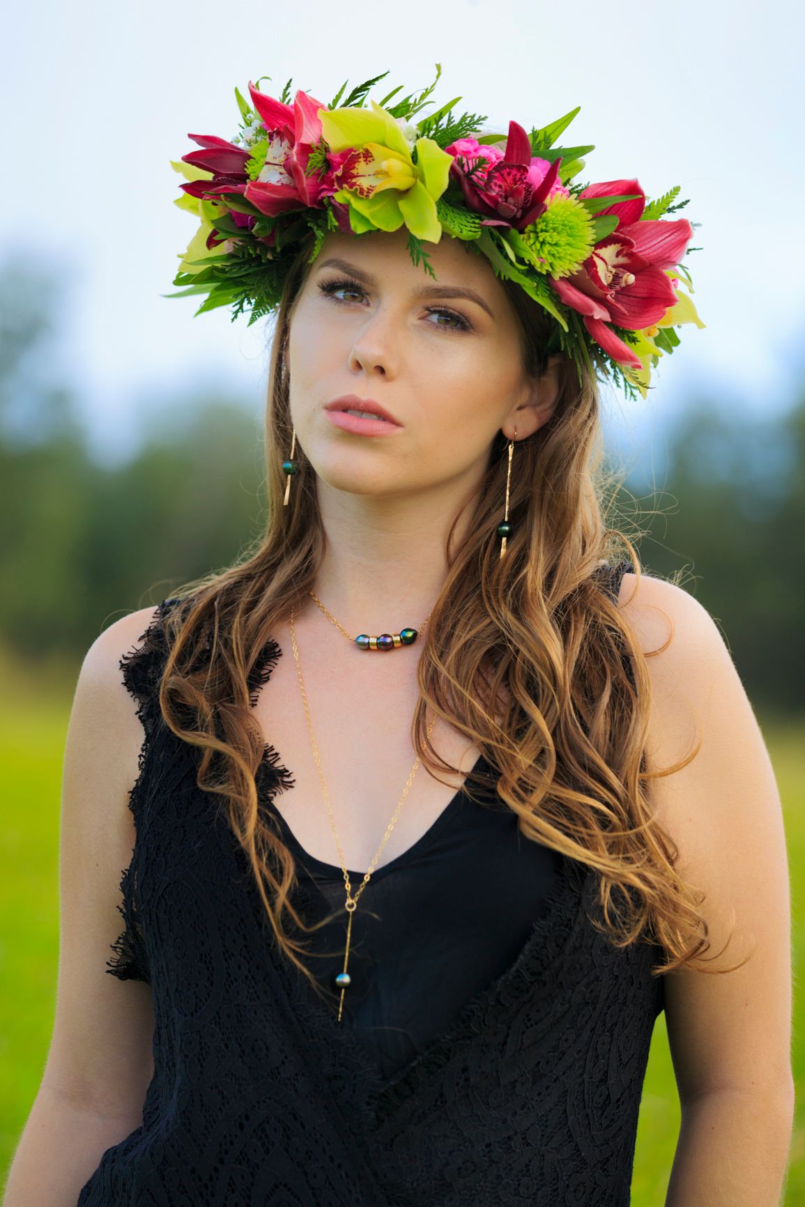 Dramatic portrait with vibrant tropical flower crown and black lace top.
