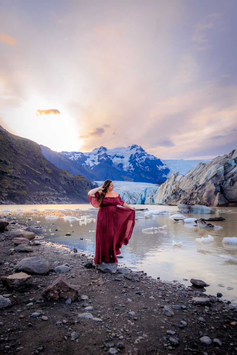 Majestic glacier landscape with dramatic mountains and icy waters at sunset.