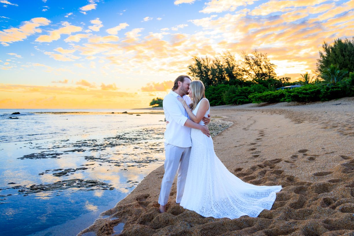 A stunning beach wedding photo at sunset with golden light.