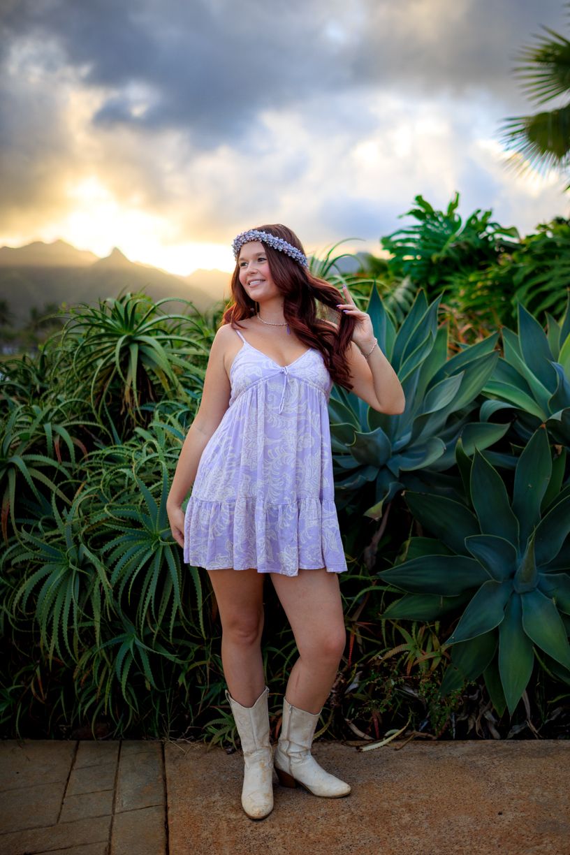Fashion photography in a tropical garden setting with dramatic mountain backdrop.